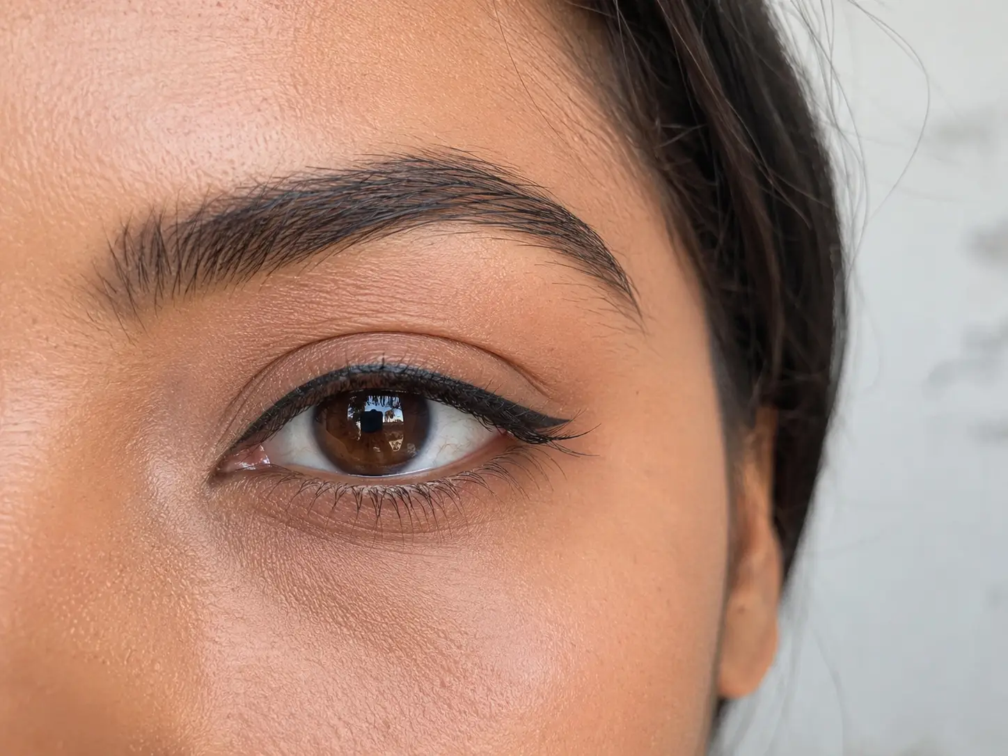 Waterproof eyeliner product on a clean vanity surface with water droplets