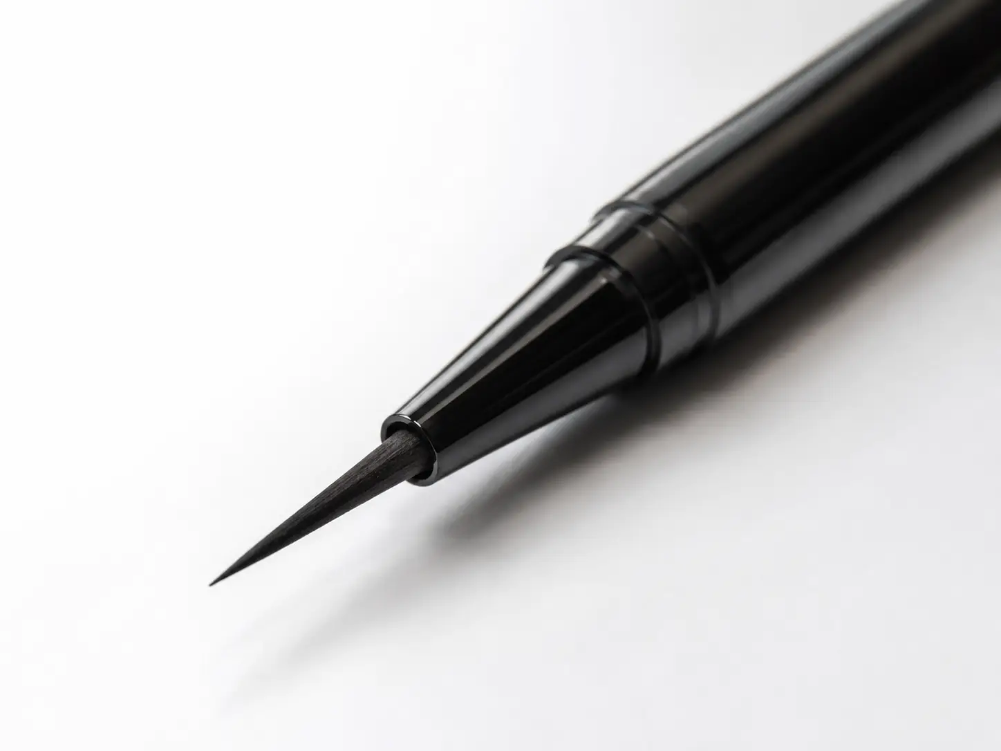 Waterproof eyeliner product on a clean vanity surface with water droplets